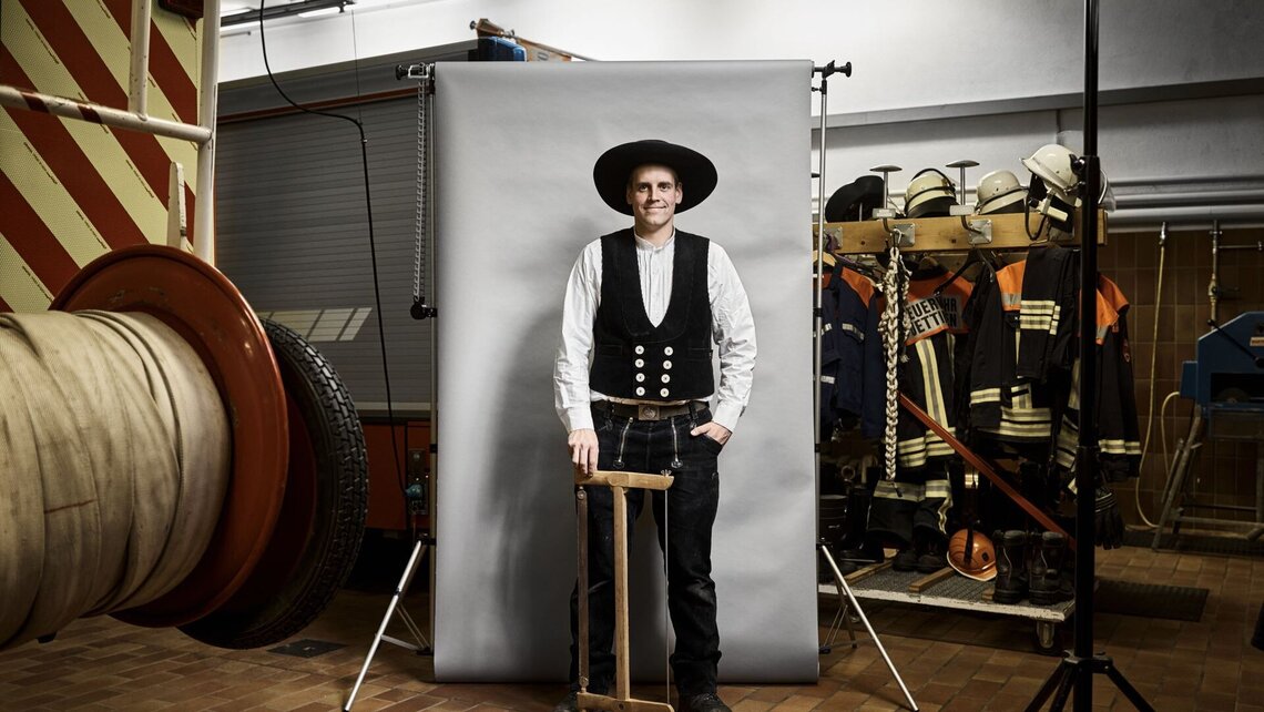 Chris im Zimmermann-Outfit in der Fahrzeughalle der Feuerwehr.