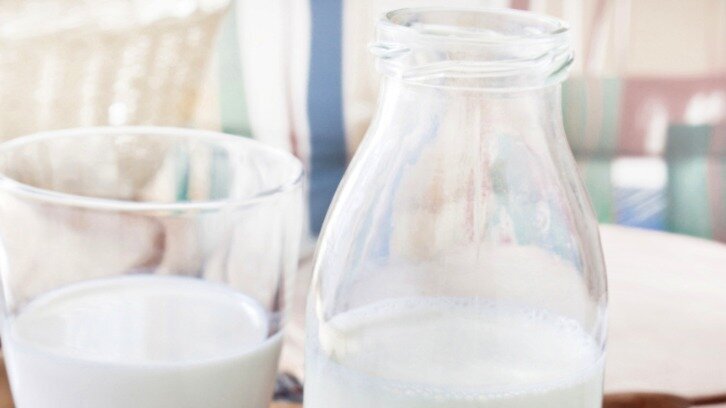 Halbvolle Milchflasche aus Glas