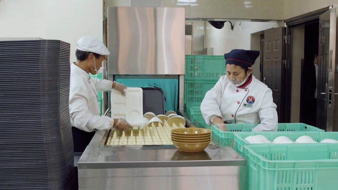 Staff tidy clean dishes into crates