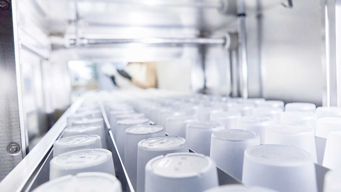 Mehrwegbecher in einer M-iQ Mehrwegbecher verlassen die M-iQ Gewerbespülmaschine